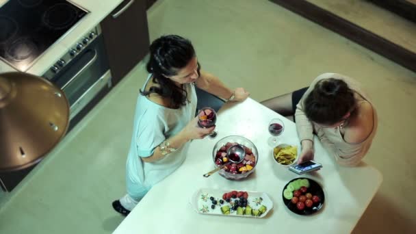 Dvě kamarádky, mluví, směje se u stolu v kuchyni doma — Stock video