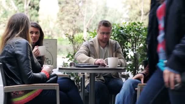 Jonge groep van vrienden praten in café — Stockvideo