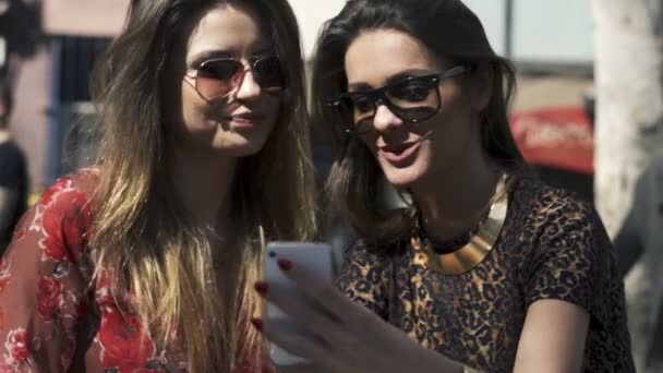 Flickvänner med smartphone sitter på city Café — Stockvideo