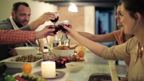 Happy friends raising toast by dinner table at home — Stock Video