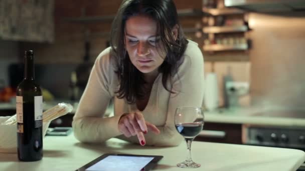 Mujer joven viendo fotos en la computadora tableta junto a la mesa — Vídeos de Stock