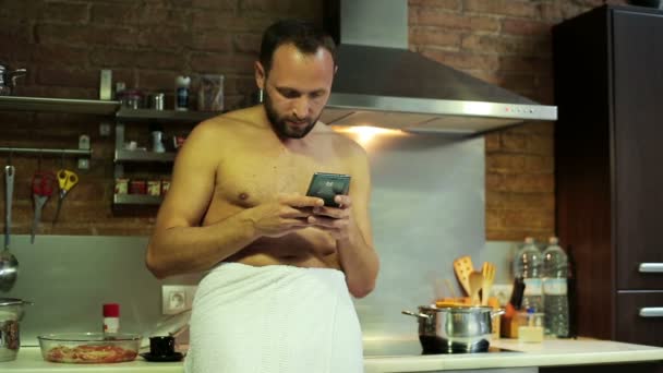 Man texting op smartphone en drinken koffie na douche — Stockvideo