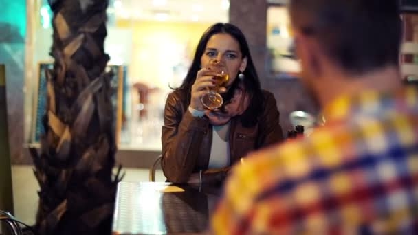 Casal jovem conversando na data no bar ao ar livre à noite — Vídeo de Stock