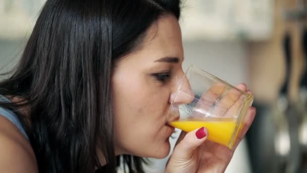 Mujer joven bebiendo jugo de naranja fresco — Vídeo de stock