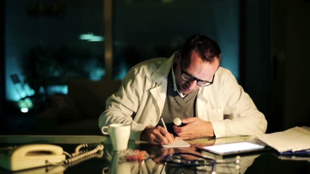 Doctor writing rx prescription at office late at night — Stock Video