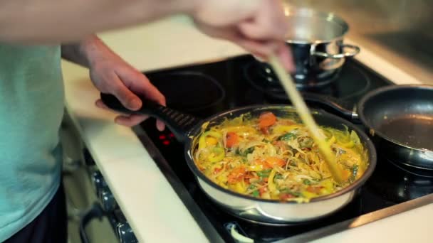 Man mixing and tasting vegetables on frying pan — Stock Video