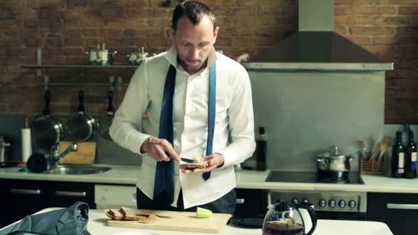 Empresario preparando su desayuno en la cocina en casa — Vídeo de stock