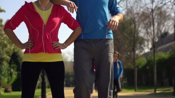 Felices corredores, pareja de pie en el parque — Vídeo de stock