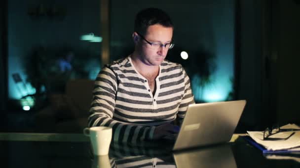 Homem de surf na web no laptop no quarto escuro à noite — Vídeo de Stock