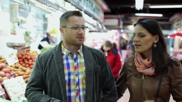 Couple shopping, looking at vegetables in vegetable market — Stock Video