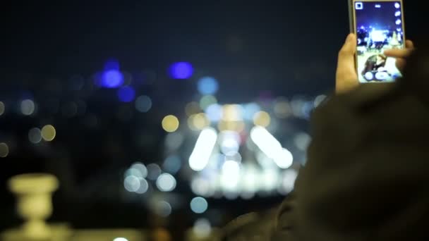 Мужчина фотографирует с мобильного телефона прекрасный вид на Барселону ночью — стоковое видео