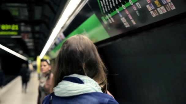 Två unga flickvänner talar och ser på tunnelbane karta — Stockvideo