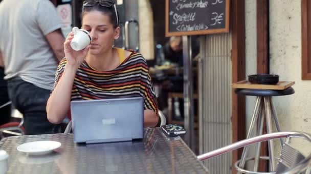 Frau mit Laptop trinkt Kaffee im Café — Stockvideo