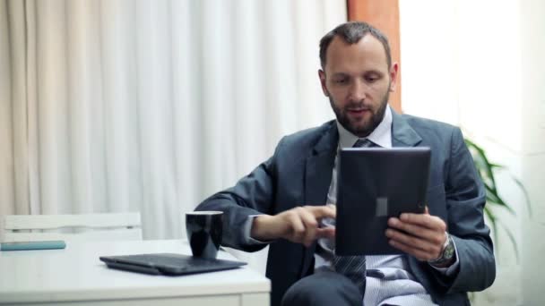 Бизнесмен пьет кофе и пользуется планшетным компьютером на террасе — стоковое видео
