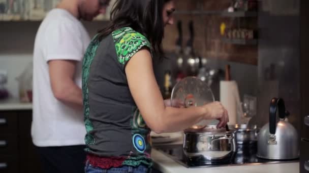 Jovem casal cozinhar refeição na cozinha em casa — Vídeo de Stock