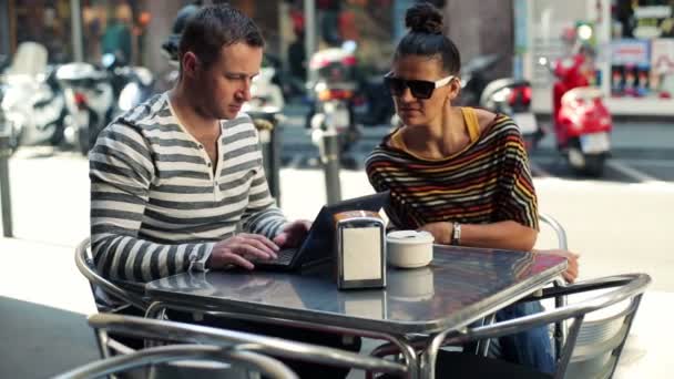 Junges Paar unterhält sich über modernen Laptop im Café — Stockvideo