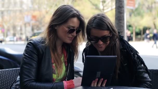 Twee vriendinnen met tablet pc zitten in Cafe — Stockvideo