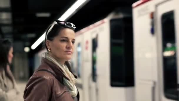 Люди ждут и садятся в поезд метро — стоковое видео