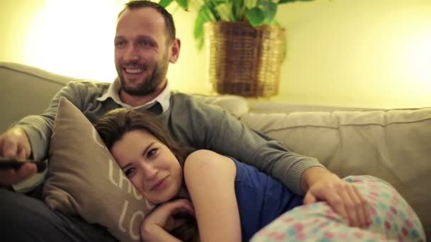 Jovem casal no sofá assistindo tv em casa, noite tempo — Vídeo de Stock