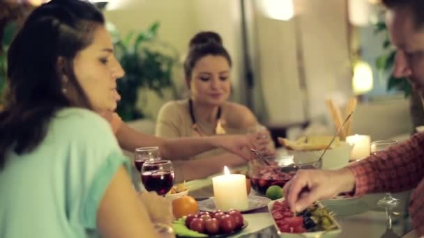 Jóvenes cuatro amigos charlando durante la cena en casa — Vídeos de Stock