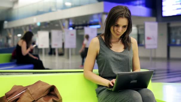 Bella donna che lavora sul computer portatile alla stazione ferroviaria — Video Stock