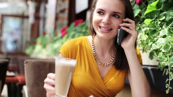 Femme élégante parlant sur son téléphone portable, buvant du café au restaurant — Video