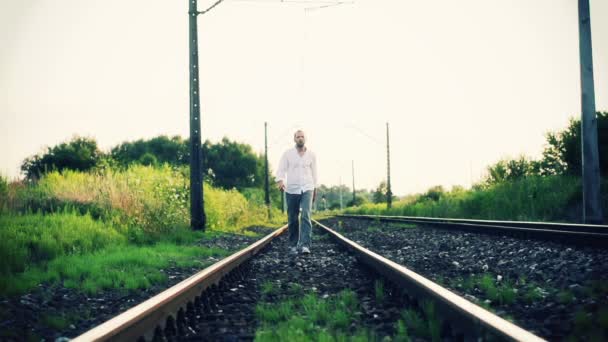 Homem caminhando em trilhas ferroviárias — Vídeo de Stock