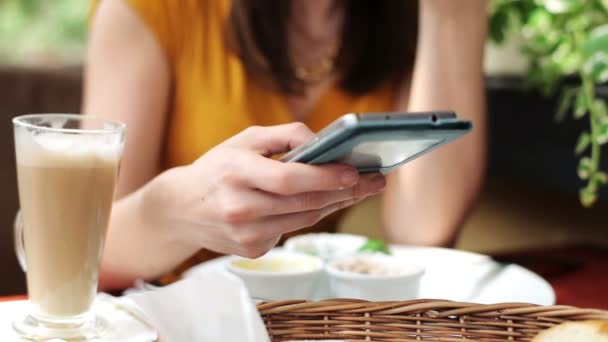 Mujer manos mensajes de texto en el teléfono inteligente en el restaurante — Vídeos de Stock