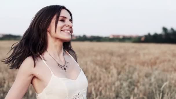 Szczęśliwy, piękna kobieta, obracając rundy na polu pszenicy — Wideo stockowe