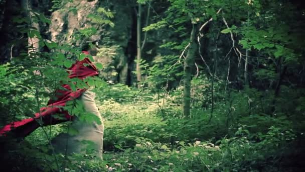 Vackra mystiska red riding hood promenader i skogen — Stockvideo