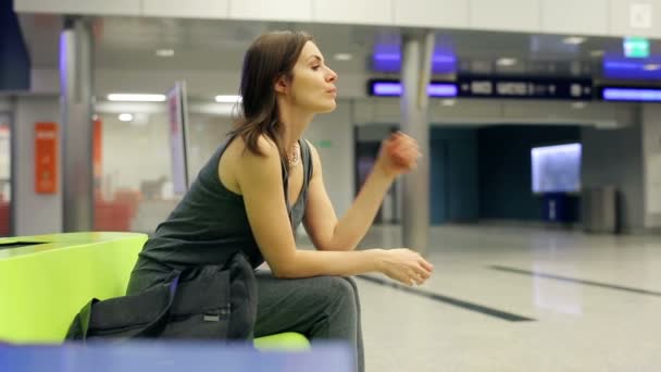 Fundersam, ledsen kvinna väntar vid järnvägsstationen — Stockvideo