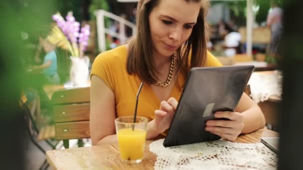 Mujer elegante con la tableta de ordenador sentado en la cafetería — Vídeos de Stock