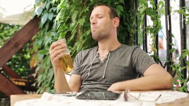 Hombre feliz bebiendo cerveza fría en el bar al aire libre — Vídeo de stock