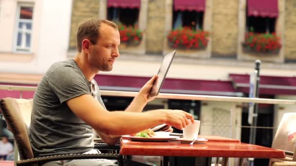 Hombre con Tablet PC beber café en el restaurante — Vídeo de stock