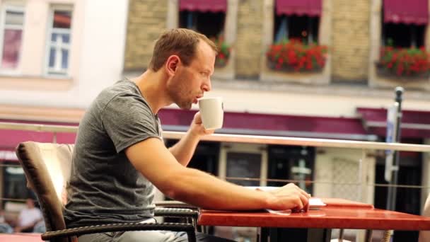 Junger Mann mixt und trinkt Kaffee in Restaurant — Stockvideo