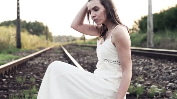 Zamyšlená žena sedící na železniční trati — Stock video
