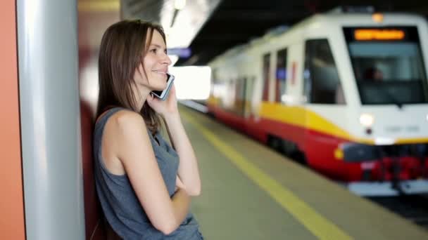 Frau spricht am Bahnhof mit Smartphone — Stockvideo