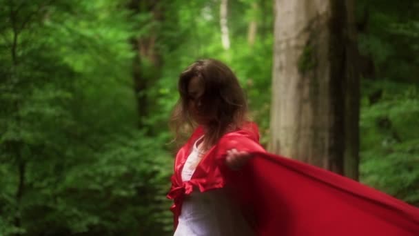 Vackra mystiska red riding hood promenader i skogen — Stockvideo