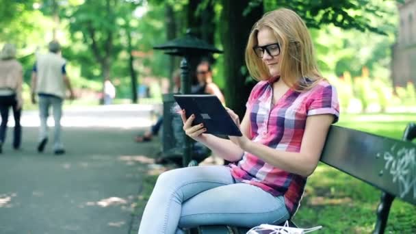 Adolescente con Tablet Computer en el parque — Vídeo de stock