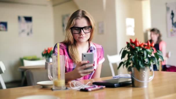 Menina mensagens de texto no smartphone no café — Vídeo de Stock