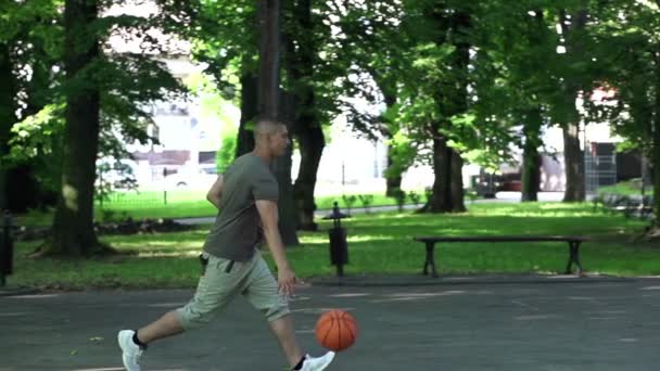 Uomo che gioca a basket sul campo — Video Stock