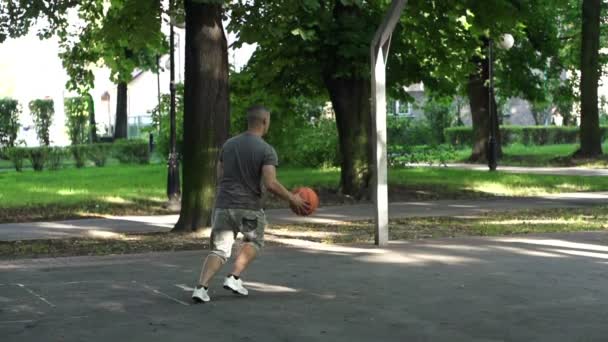 Мужчина играет в баскетбол — стоковое видео