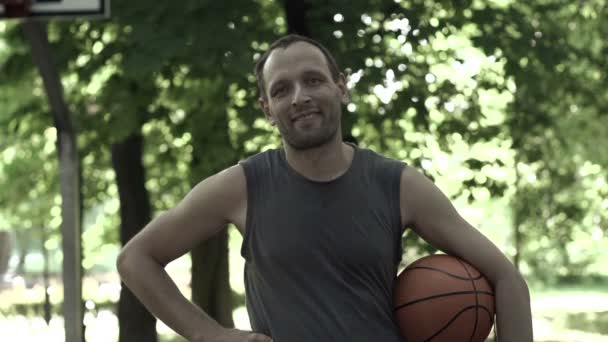 Gelukkig basketbalspeler in park — Stockvideo