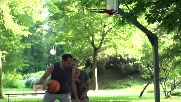 Twee mannen die basketbal spelen — Stockvideo