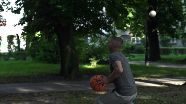 Mann spielt Basketball auf dem Platz — Stockvideo