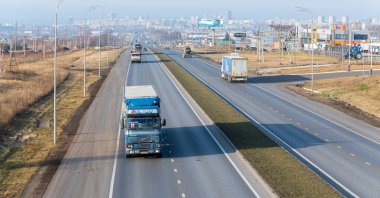 Tataristan, Rusya, Otoyol M7 - 4 Kasım 2020. Kamyonlar federal otoyol boyunca gidecekleri yere doğru hareket ediyor. Arka planda, ufukta, Naberezhnye Chelny şehri. KAMAZ kamyonları yaptığım şehir.