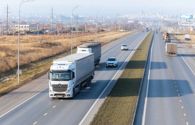 Tataristan, Rusya, Otoyol M7 - 4 Kasım 2020. Kamyonlar federal otoyol boyunca gidecekleri yere doğru hareket ediyor. Arka planda, ufukta, Naberezhnye Chelny şehri. KAMAZ kamyonları yaptığım şehir.