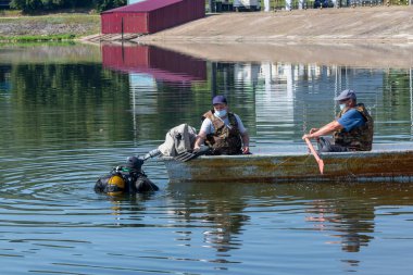 Rusya, Volga Nehri Kama - 5 Ağustos 2020. Antiviral maskeler profesyonel dalgıç asistanları. Denizaşırı sanayi işgali. Ticari açık deniz dalışı