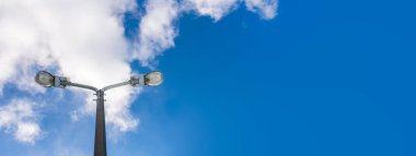İki kollu sokak lambası klasik sokak lambası bulutlu mavi gökyüzünün önünde duruyor. Sokak lambasının alt görüntüsü. Sokak Billboard panoları dokusu için Mavi Açık Gökyüzü ile Copyspace.