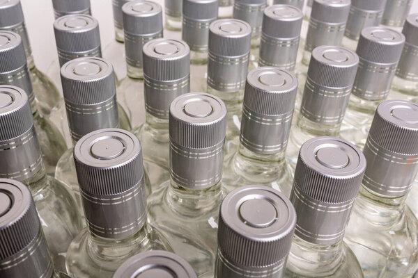 Множество чистых бутылок алкоголя не помечены. Бутылки домашнего алкоголя. Небольшое производство ликёра на основе дистилляции. Бьет пустые полные ряды.  